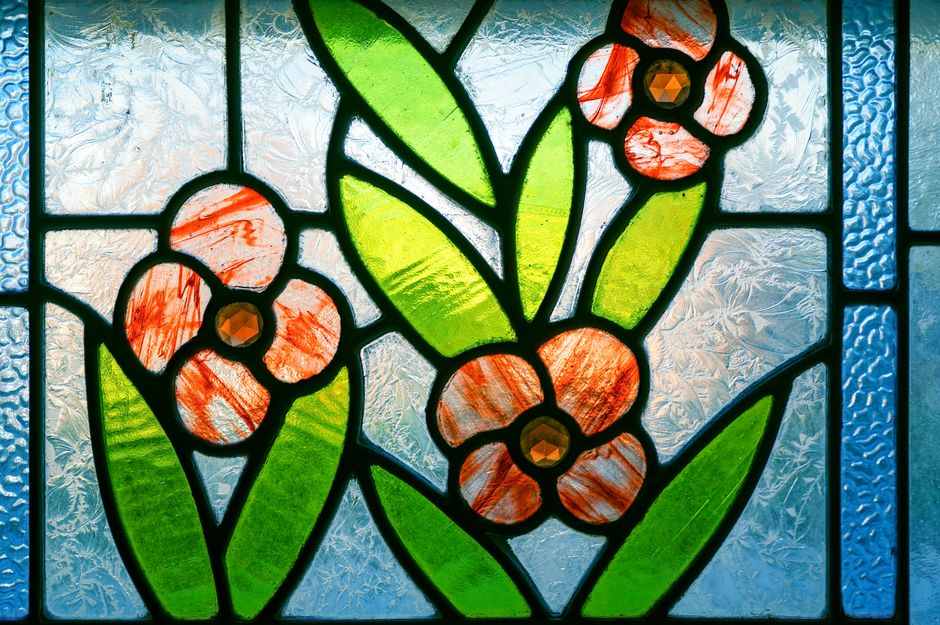 Kleurrijk glasschilderij met waterdruppels in witte badkamer.